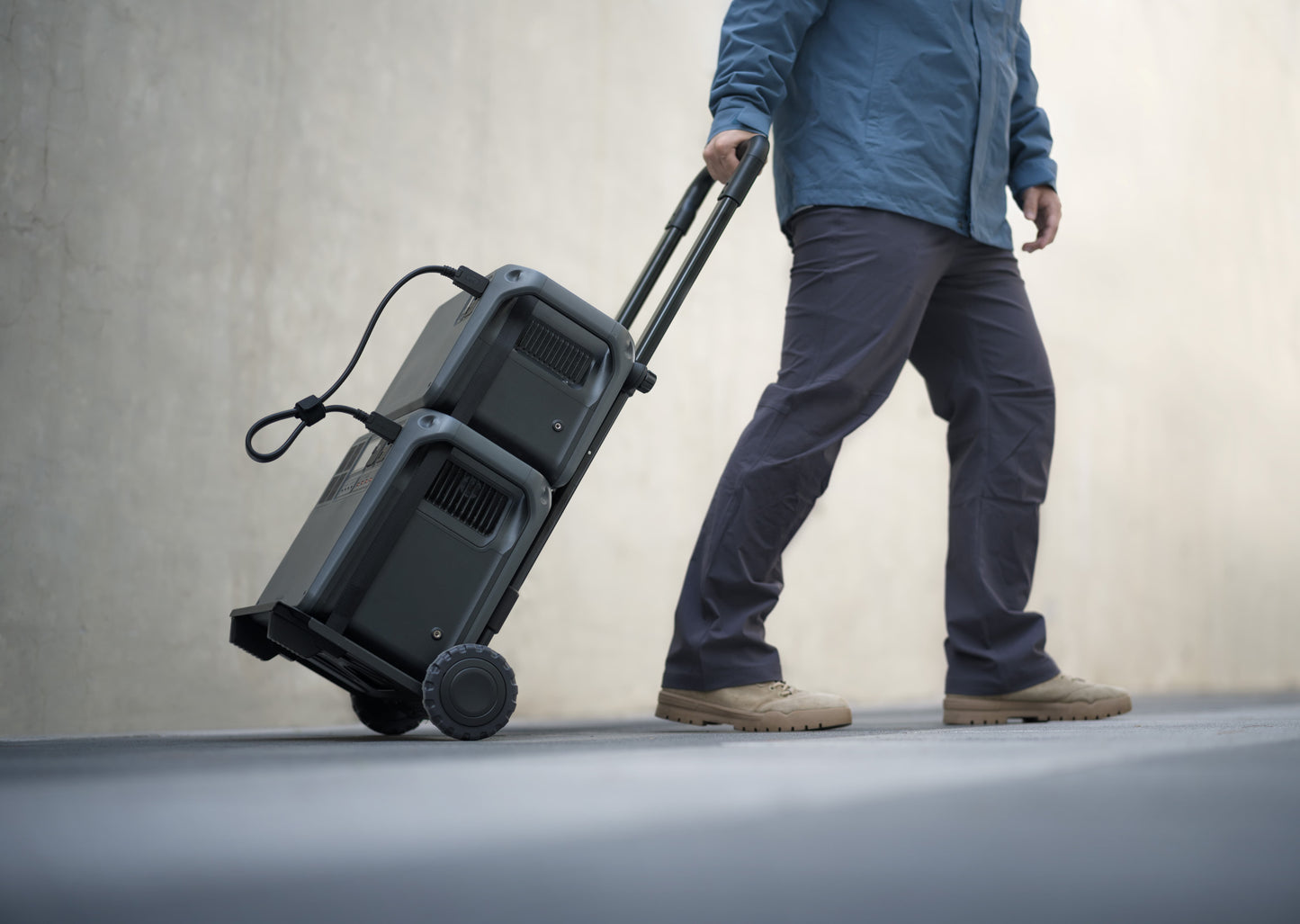 DJI Hand Truck in use by a man transporting power gear — rugged, ergonomic trolley ideal for job sites, field work, and mobile power setups; built for tradies and contractors, available from Yakka Gear.