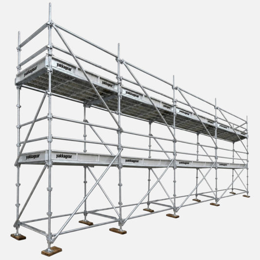 Yakka Gear 6m reach wide Kwikstage Scaffolding system in galvanised steel, featuring a 4m platform height and 9.6m overall length, with multiple scaffold bays, guardrails, cross bracing, adjustable base jacks and Yakka Gear branded components, designed for stable elevated access on construction and building projects across Australia.
