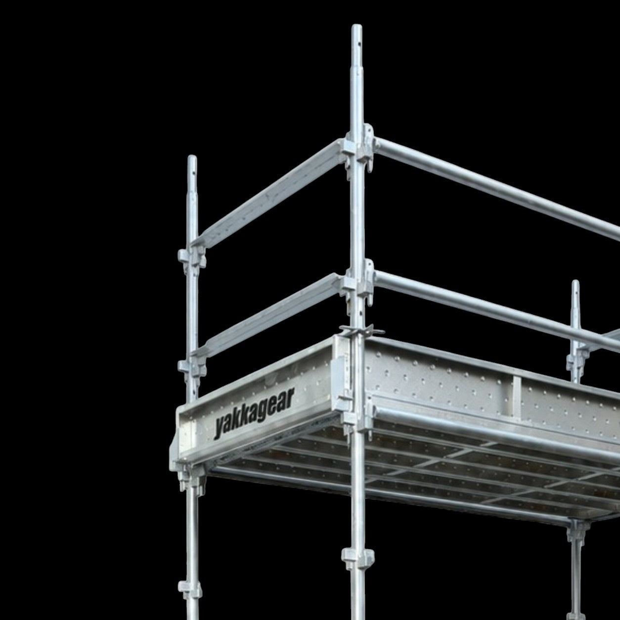 Close-up view of Yakka Gear Kwikstage Scaffolding in galvanised steel against a black background, showing the elevated working platform, Yakka Gear branded components, vertical standards and safety guardrails, highlighting the durable modular construction of the scaffolding system for building and construction applications across Australia.