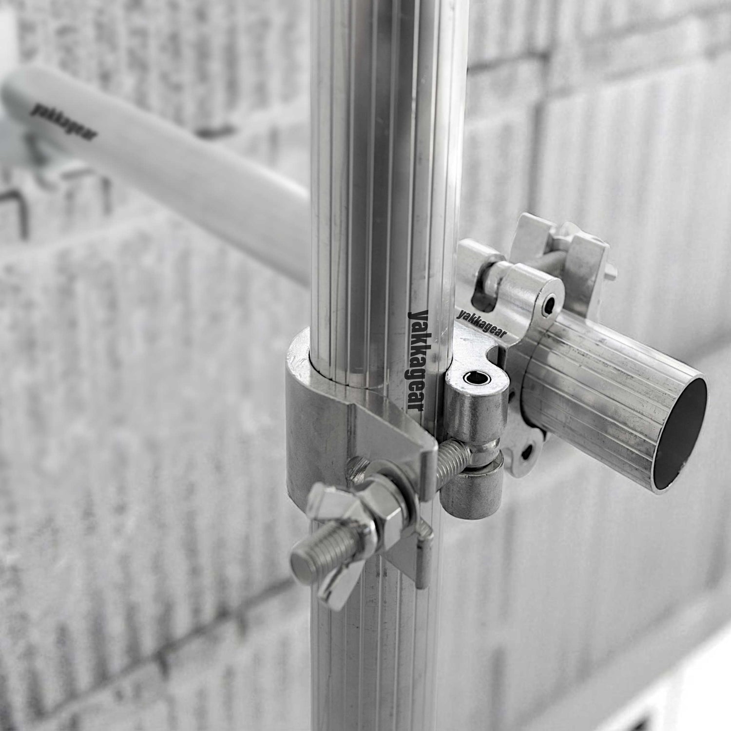 Side angle view of the Yakka Gear scaffold wall mount fixed to a wall, clamped onto 50mm–51mm tubing for Slim, Wide, and Compact scaffolds, providing secure support in tight spaces without stabiliser legs or outriggers, Australia.