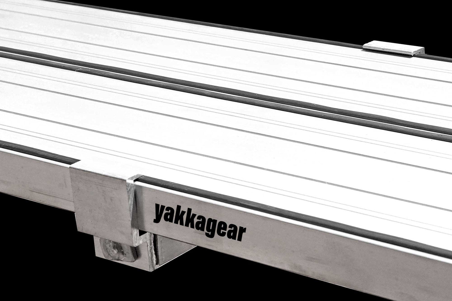Yakka Gear Australia Plank Clamp being used on two Aluminium Planks as access equipment. Joins two planks together to make the work platform twice as wide and twice as stable. Used on all sized planks including 2.5m, 3m, 3.6m, 4m, 5m and 6m planks. View from above with black background. 