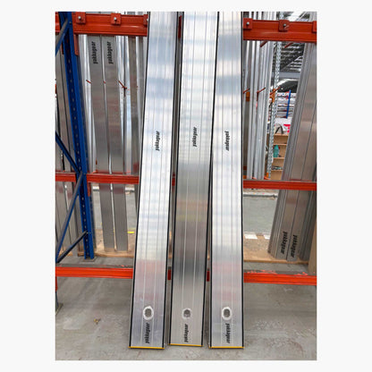 Three lockable planks leaning securely against a storage rack inside a warehouse, Yakka Gear equipment, Australia.